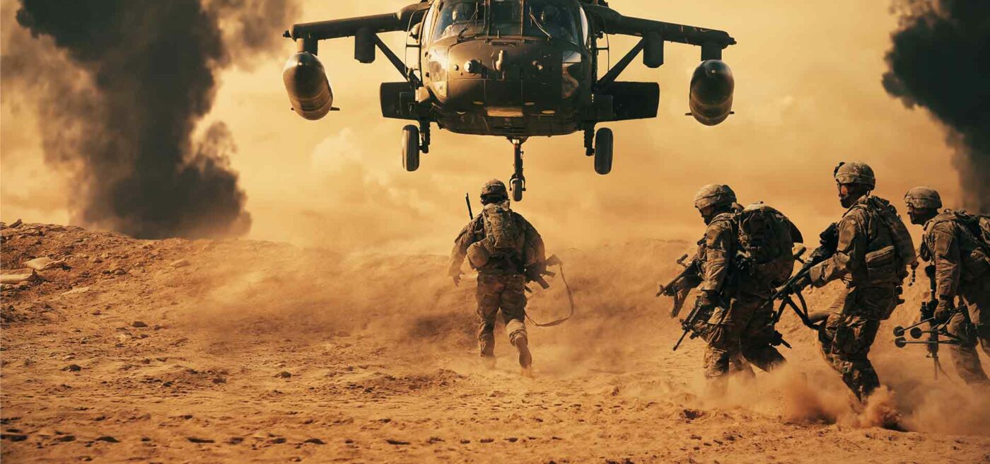 Troops crowding around attack helicopter in the desert